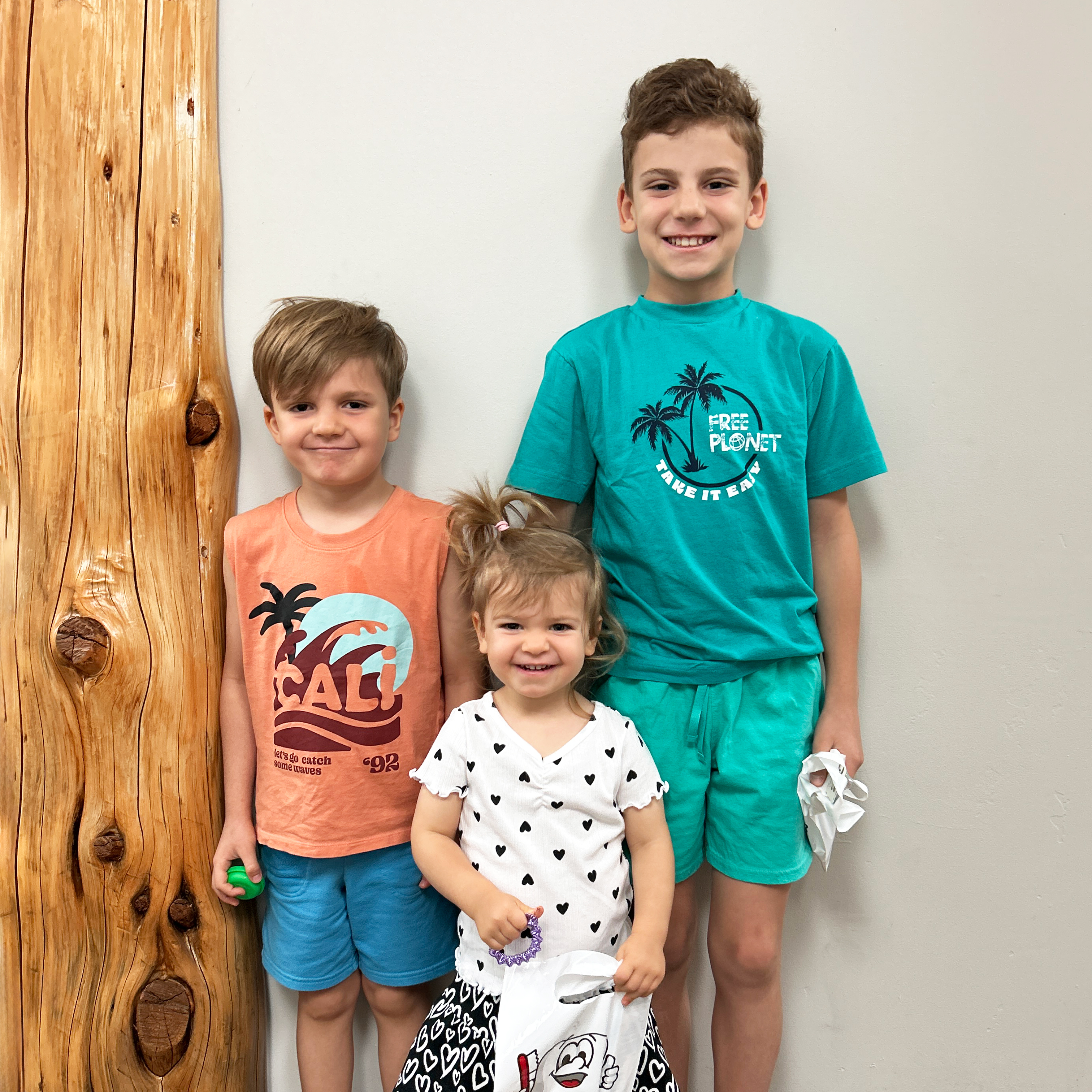 Three children smiling in a dentist office